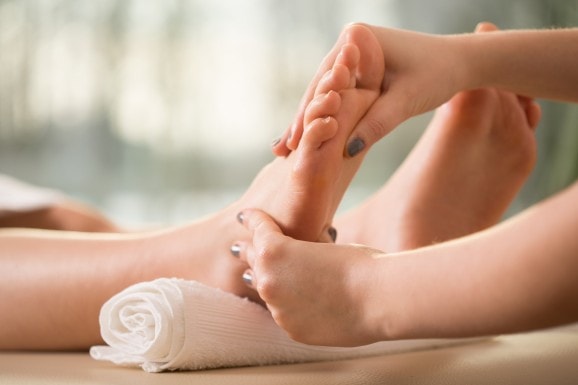 Massage d'un pied avec 2 mains