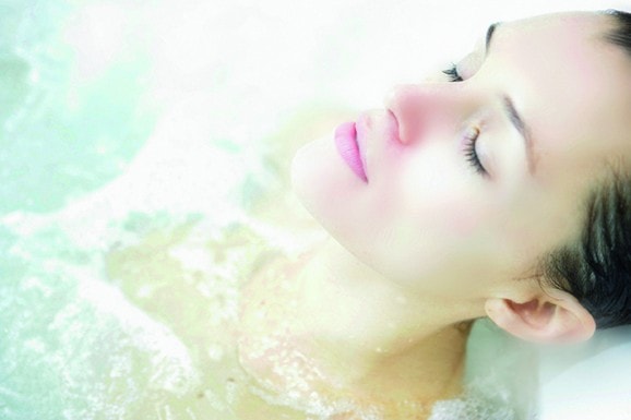 Visage d'une femme allongée dans un bain d'eau de mer