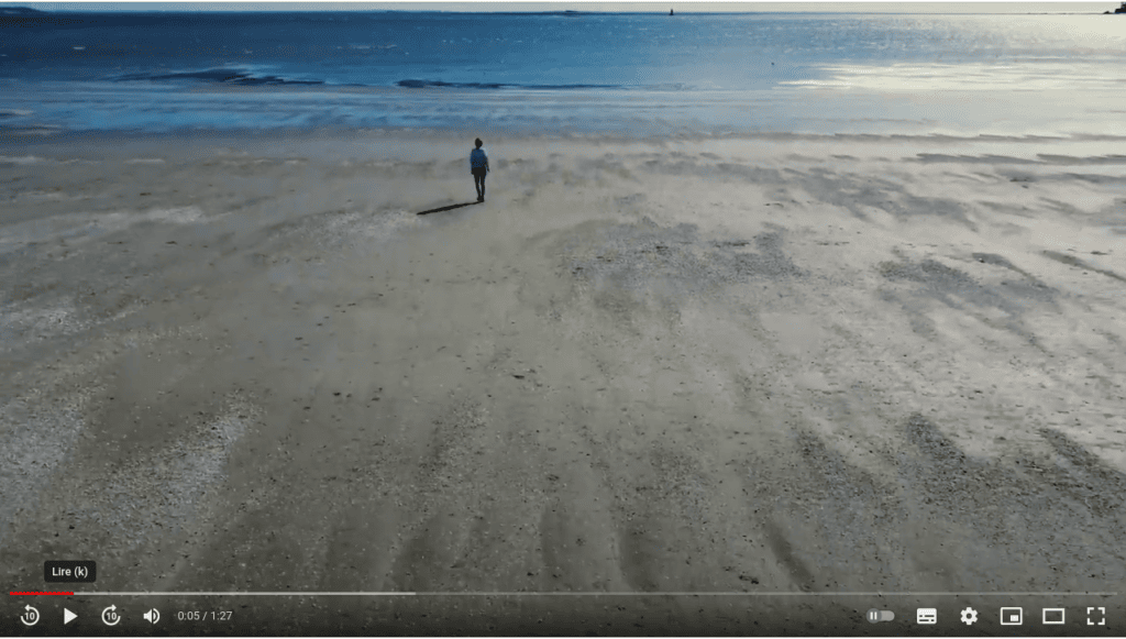 Une femme marche sur la plage de la Baule.