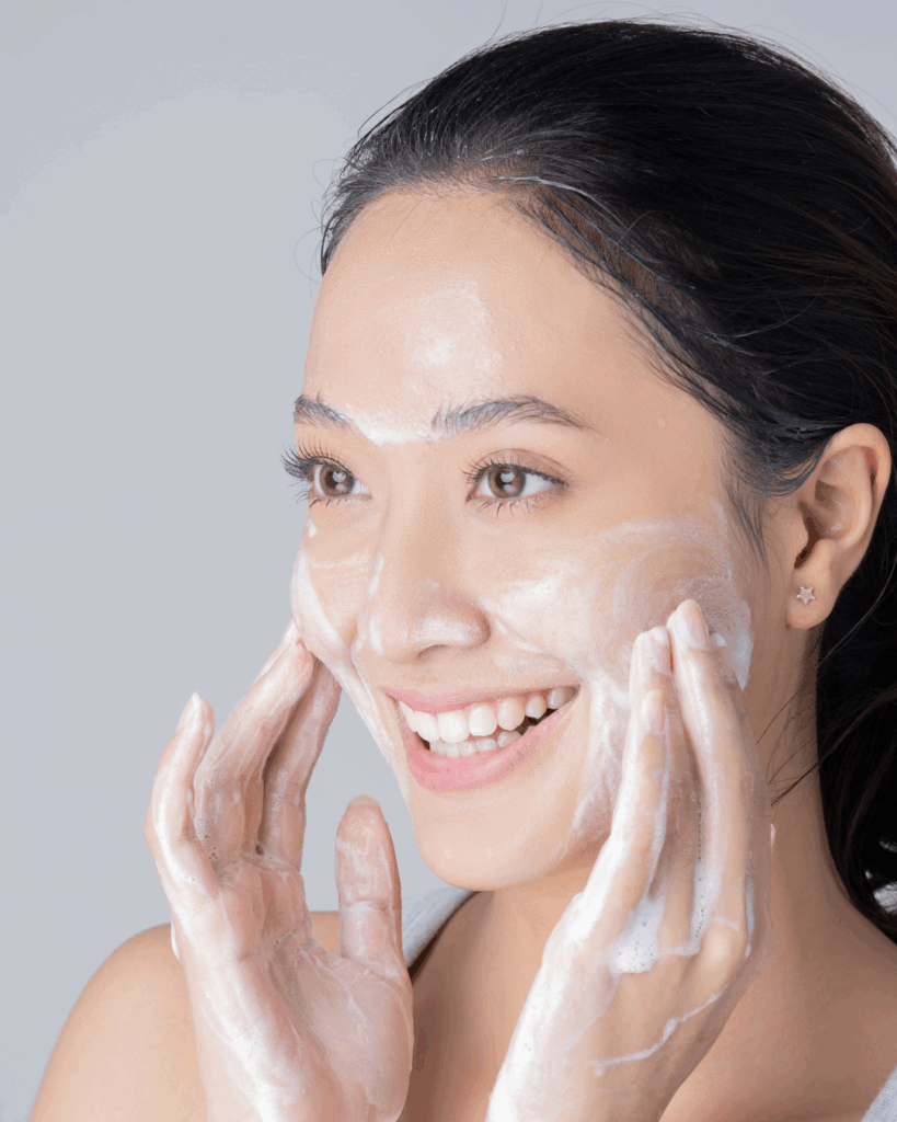 femme brune à la peau clair qui se nettoie le visage.